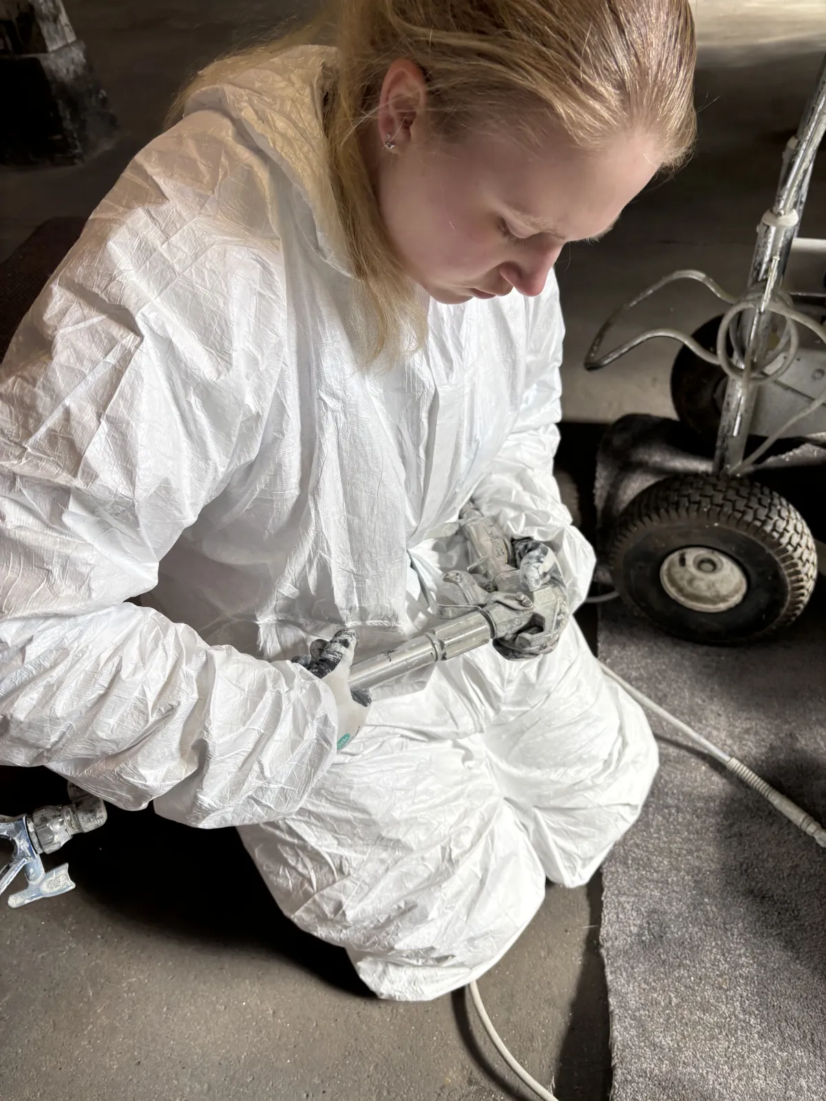 Marie, Auszubildende im 2. Lehrjahr, mit der Airless-Spritzpistole in der Hand