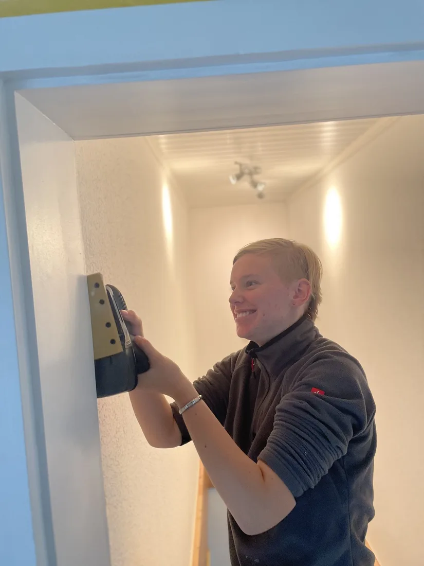 Daria beim Spachteln einer Wand
