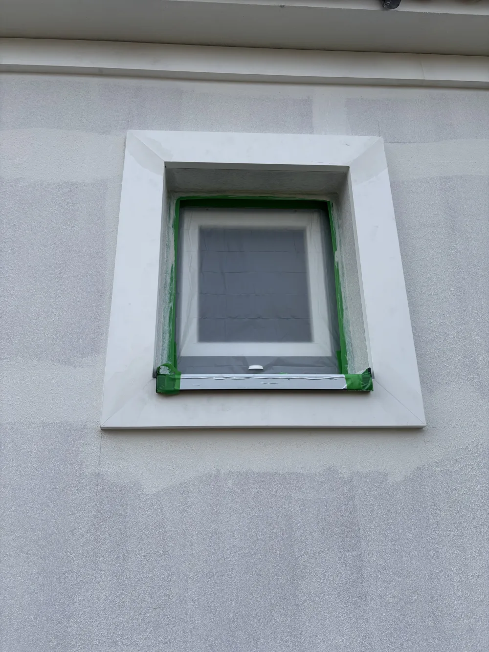 Sauber abgesetztes weißes Zierprofil rund um ein Fenster